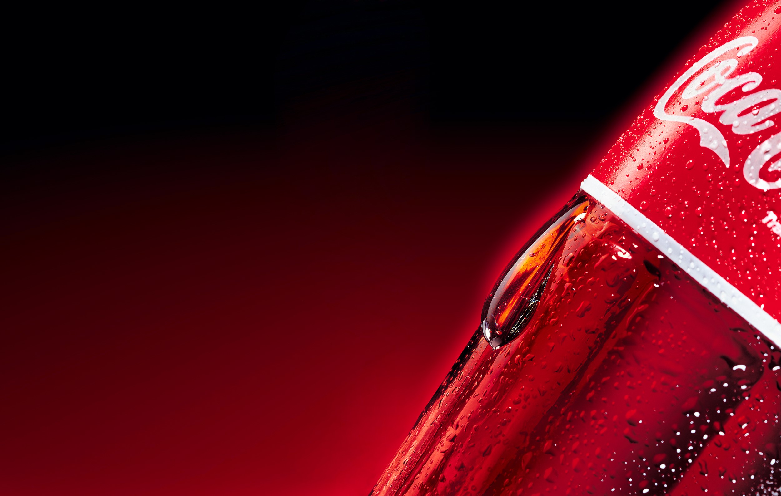 צילום סנסורי של טיפה ענקית בתנוחה טבעית של נזילה על דופן בקבוק זכוכית קוקה קולה למודעה משרד פרסום דחף אחד