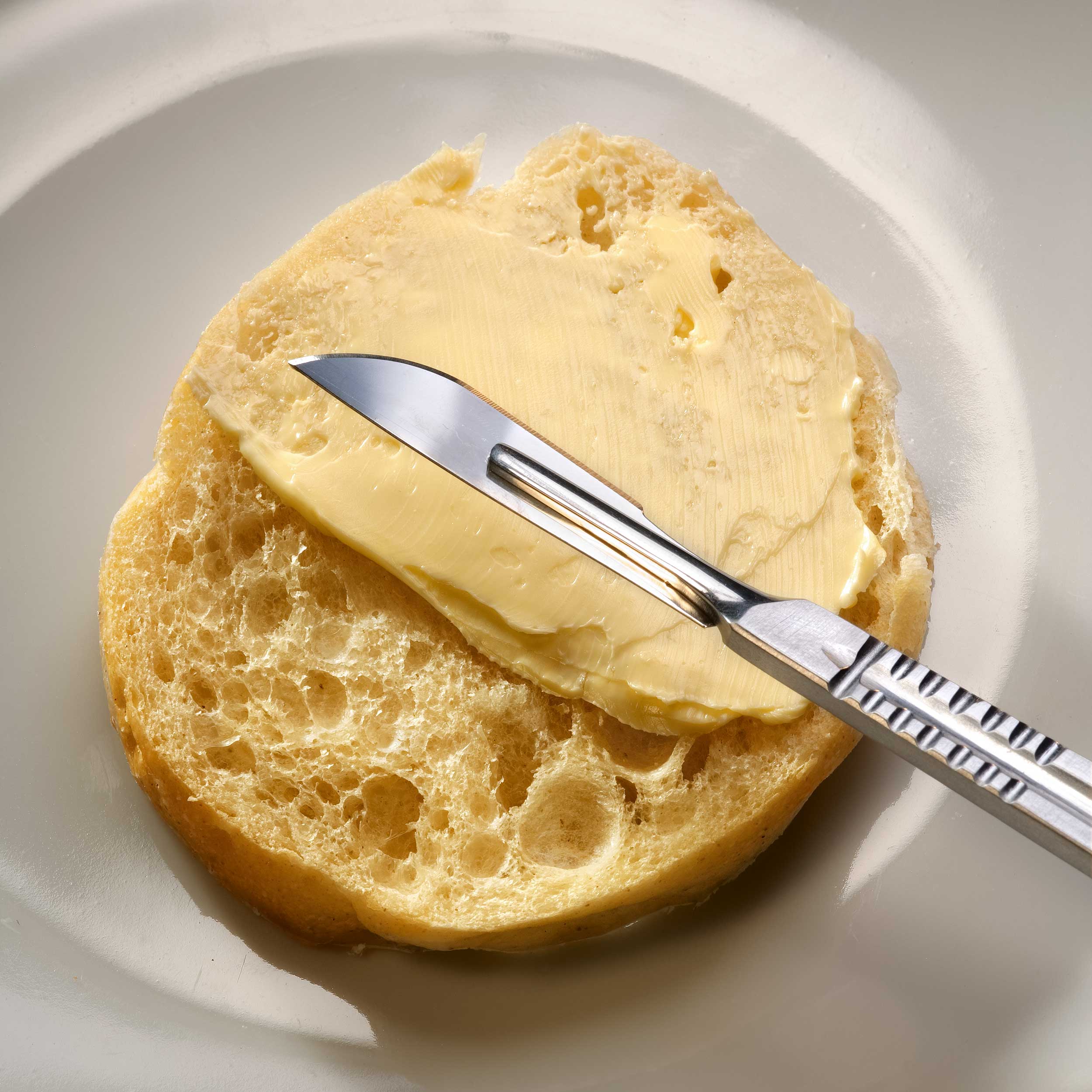 צילום למודעה צילום סכין מנתחים על בייגל עם חמאה