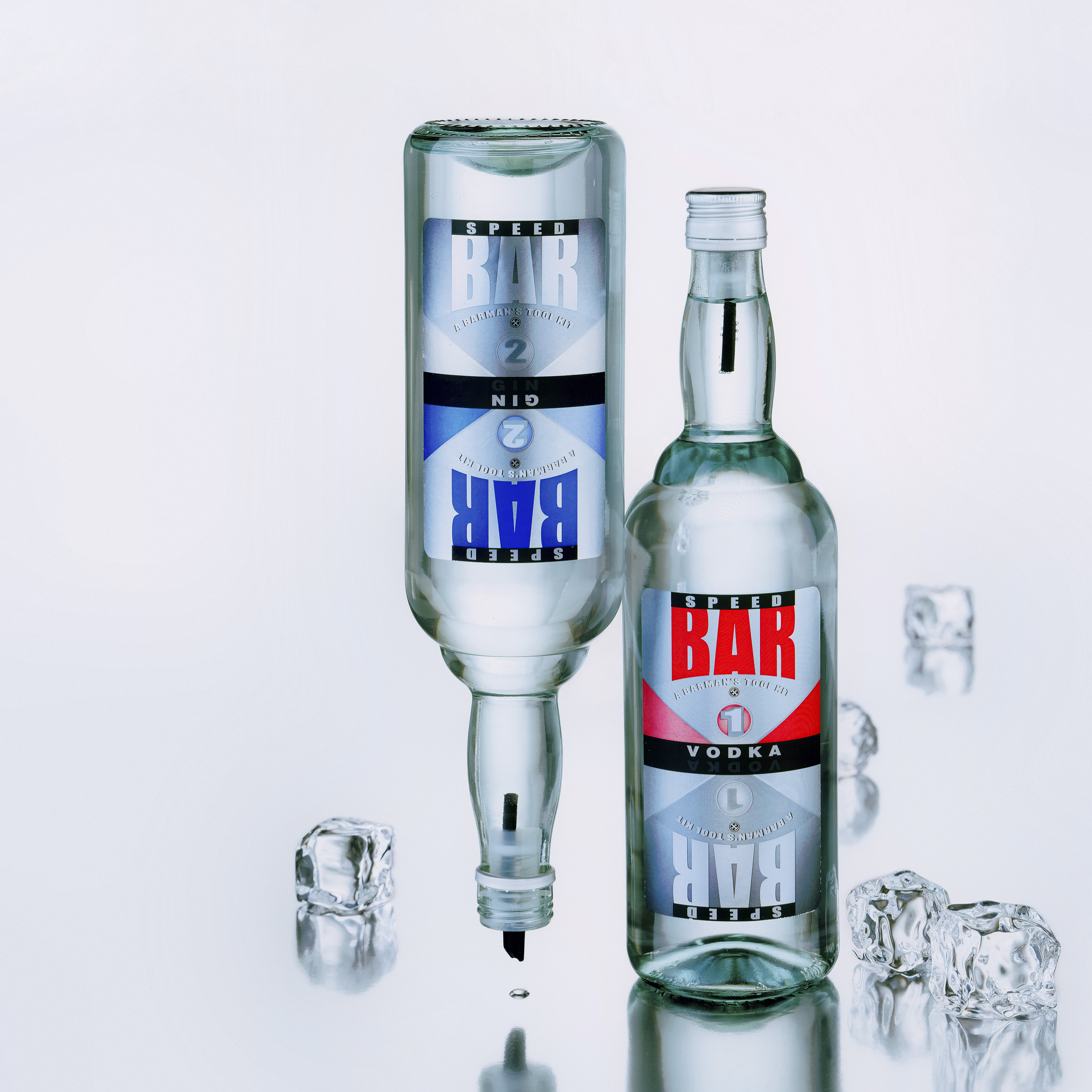 צילום מקצועי של סטודיו רייס צלמים שני בקבוקי משקה אלכוהול וודקה וג'ין על רקע משתקף בהיר עם קוביות קרח. איתי רייס מנחם