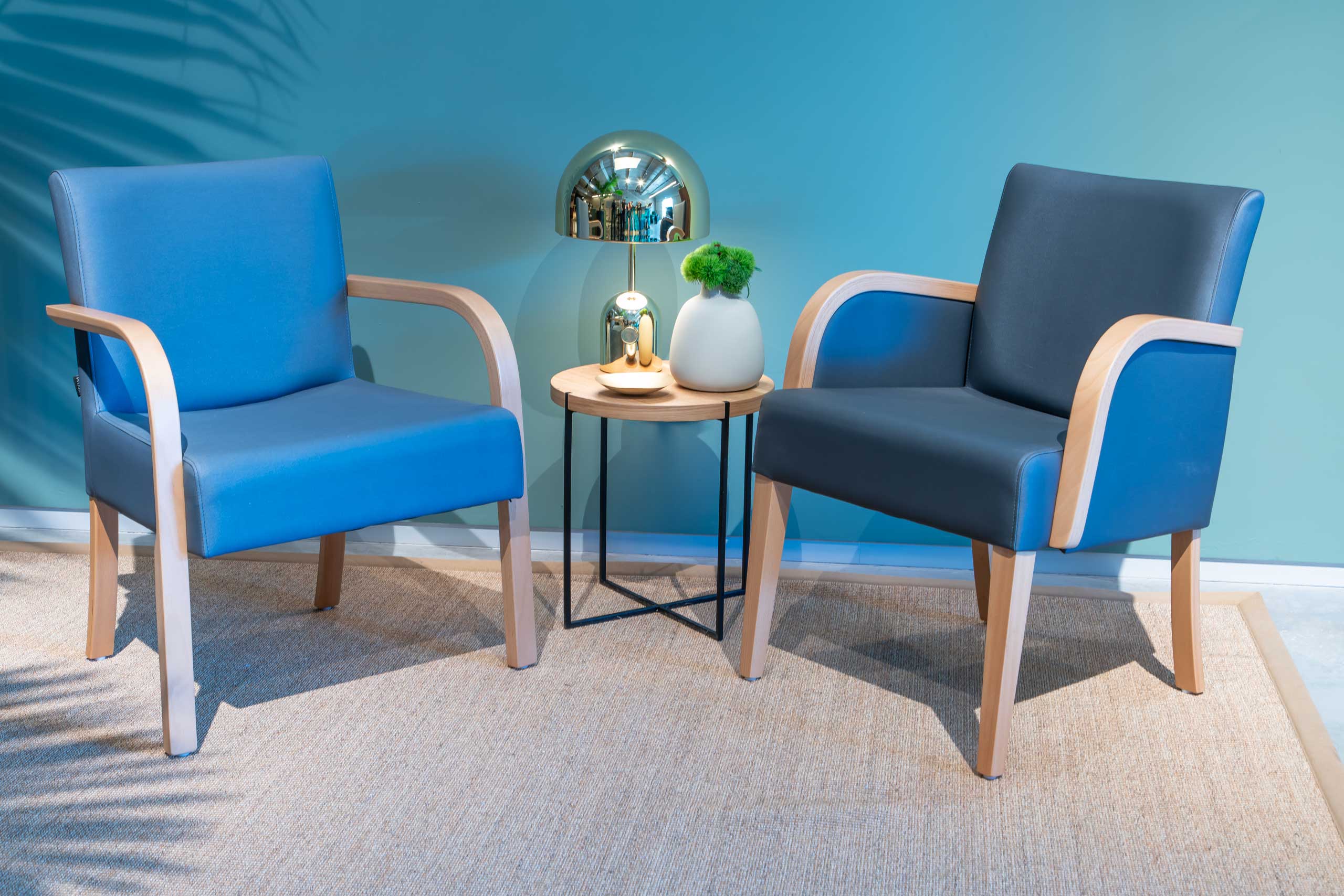 חדר תצוגה של רהיטי פיטרו לשוק המוסדי חדר המתנה כורסאות כחולות שולחן מנורה כסופה זהובה
