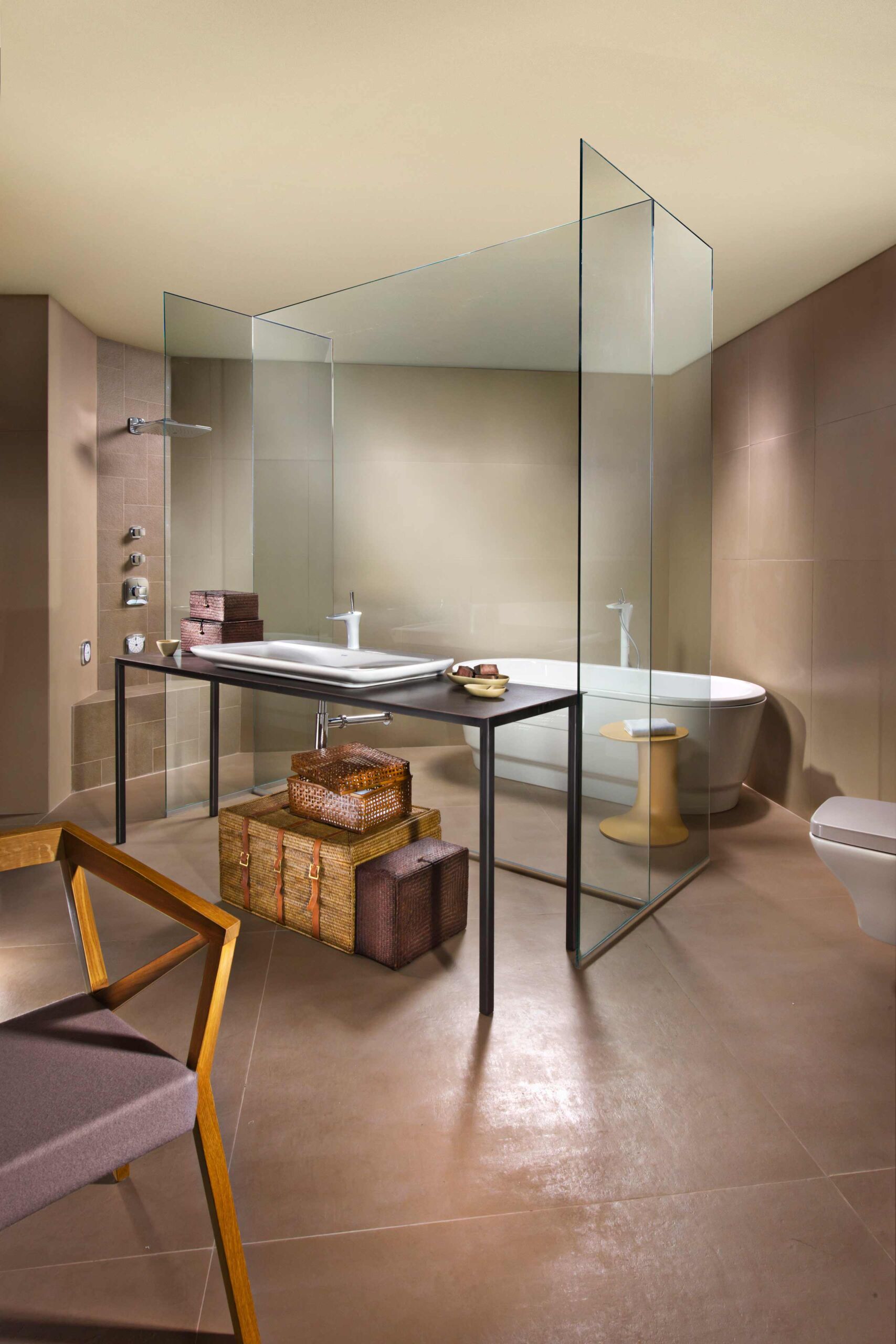 צילום עיצוב פנים בגווני חומים באולם תצוגה של זהבי עצמון חדר אמבטיה עם מקלחת גשם פרגוד זכוכית צורת H