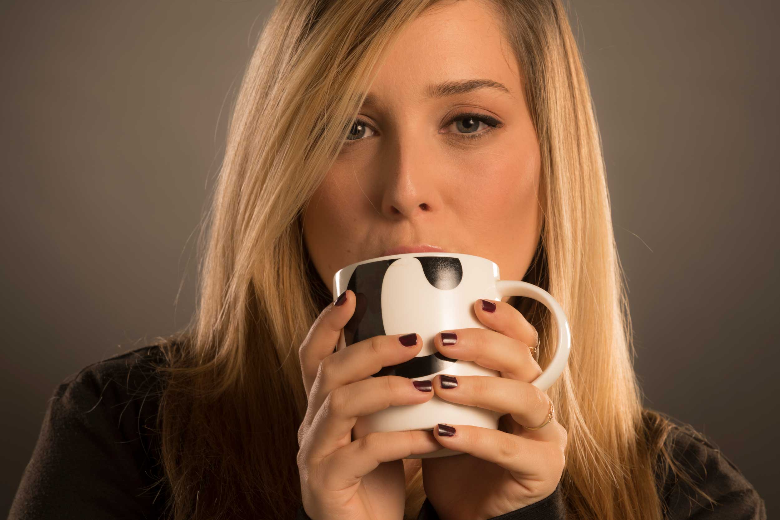 צילום דוגמנית עם כוס משקה חם - משדר רגע של שקט איכות ופינוק יומיומי